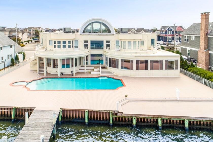 The cream-colored waterfront home opens to a private dock overlooking Barnegat Bay.