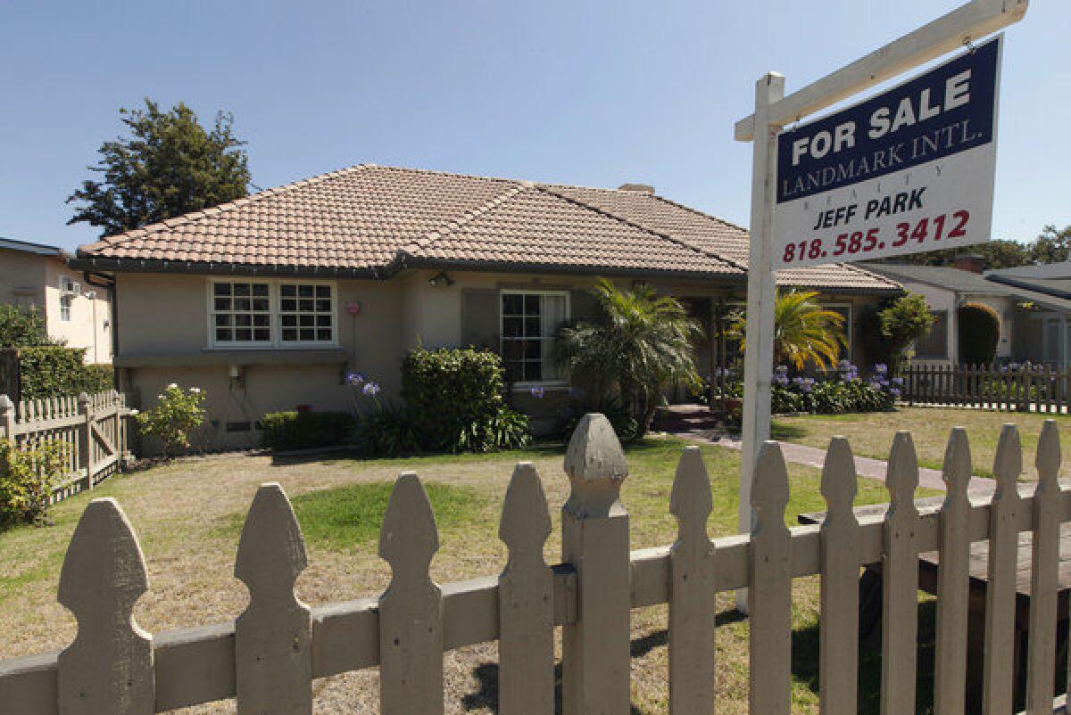 A house with a for-sale sign in the frontyard