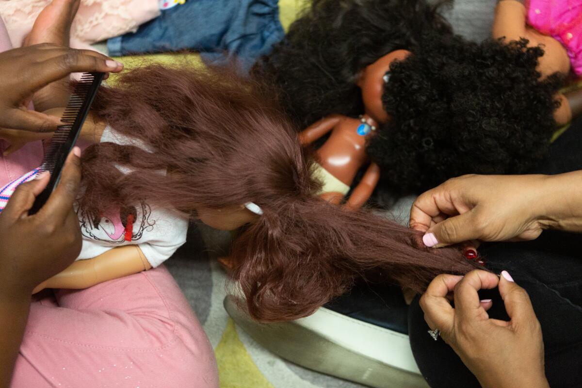 Students groom their dolls during a group therapy session at Crete Academy in South Los Angeles.