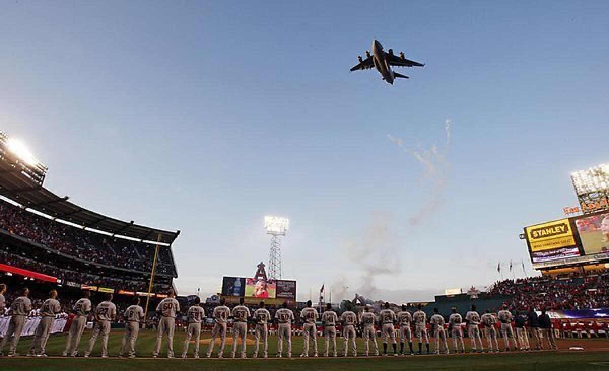 An Air Force C-17 Globemaster military transport plane flies over Angels Stadium in Anaheim on opening day in 2010.