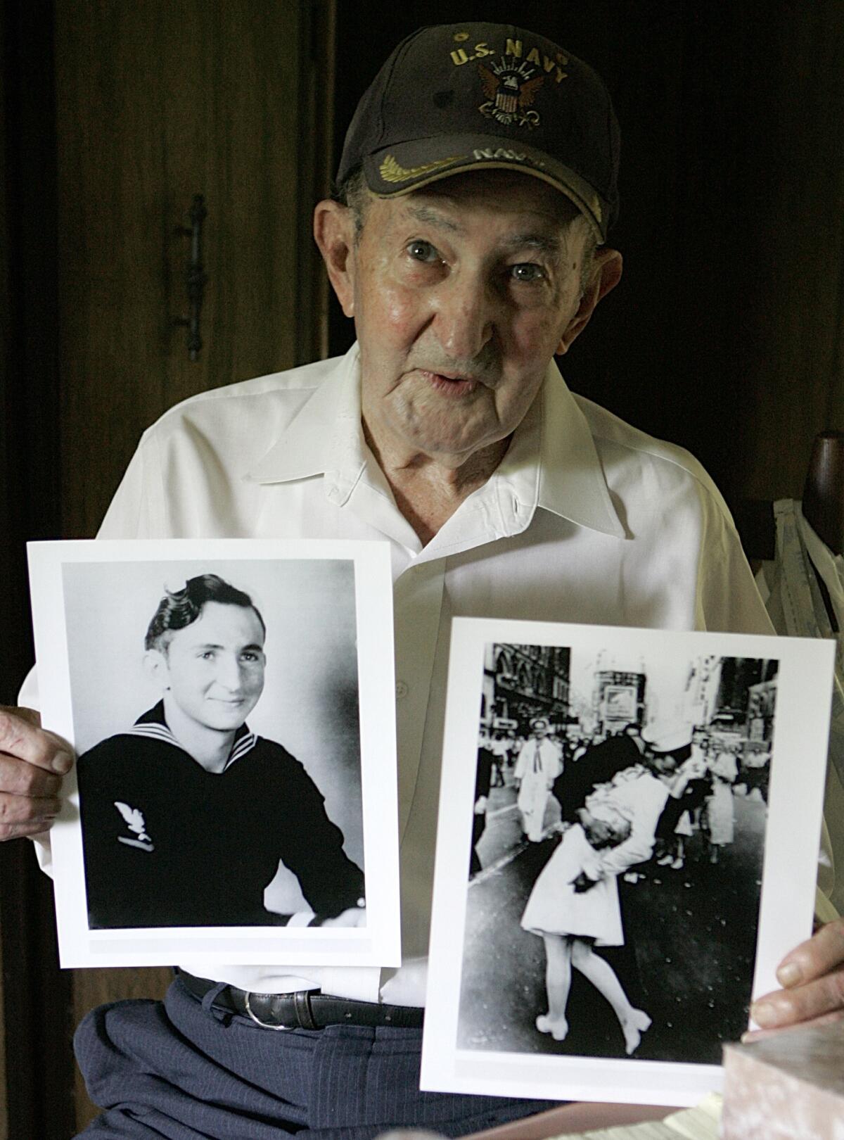 Glenn McDuffie, seen in 2007, holds a portrait of himself as a young man, left, and a copy of Alfred Eisenstaedt's iconic Life magazine shot of a sailor, who McDuffie claims is him, embracing a dental assistant in a white uniform in New York's Times Square, at his Houston home. McDuffie died on March 9 at the age of 86.