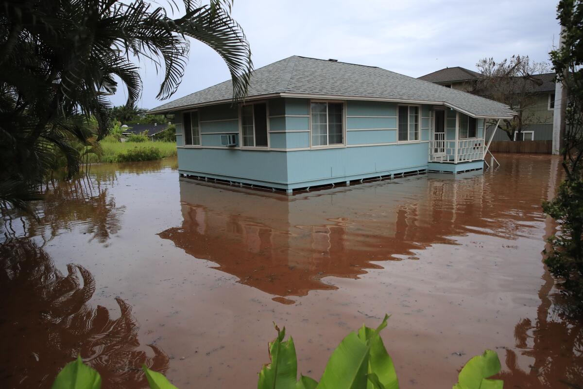 A house on Haleiwa Road is surrounded by floodwaters Tuesday, March 9, 2021, in Haleiwa, Hawaii. Torrential rains have inundated parts of Hawaii for the past several days. (Jamm Aquino/Honolulu Star-Advertiser via AP)