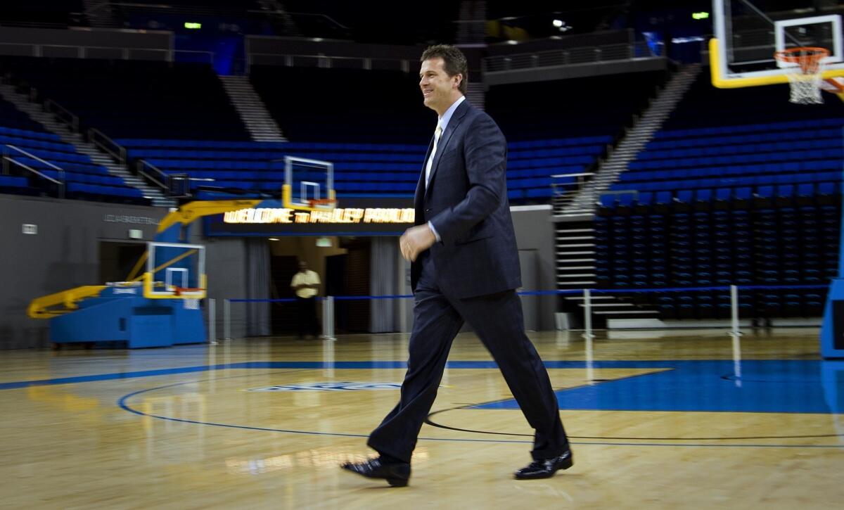 New UCLA Coach Steve Alford heads across Pauley Pavilion to meet with reporters on Tuesday.
