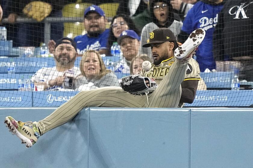 San Diego Padres outfielder Fernando Tatis Jr. is unable to handle a foul ball hit by Los Angeles Dodgers' Kiké Hernández during the 10th inning of a baseball game Friday, April 12, 2024, in Los Angeles. (AP Photo/Mark J. Terrill)