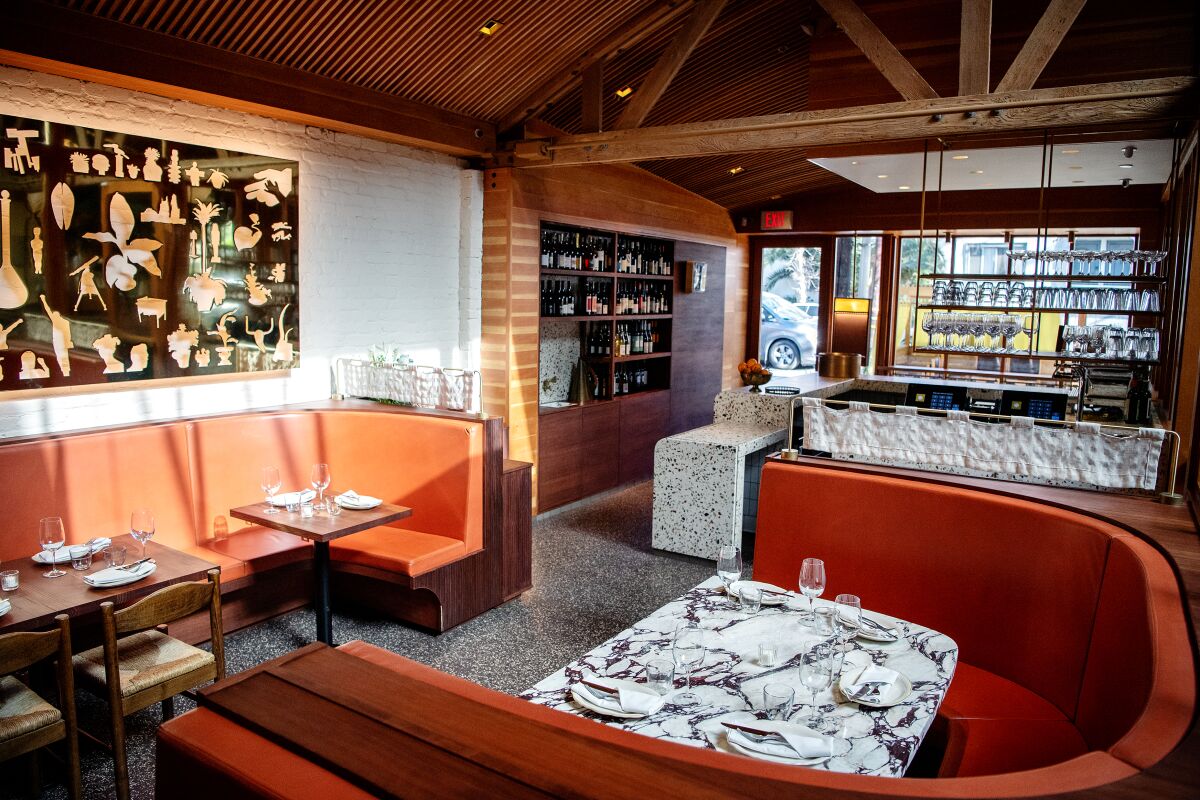 The main dining area includes an art installation on the wall from photographer Matt Lipps.