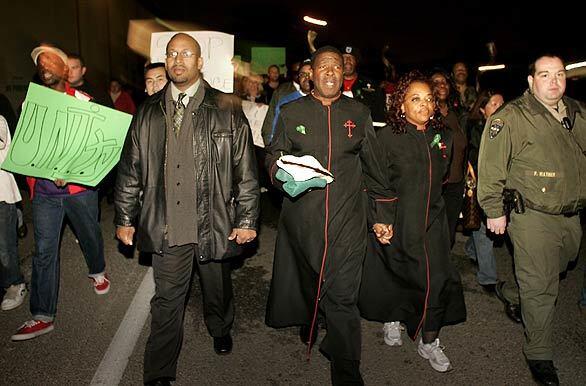 Dr. Willie Holmes and his wife, Vanessa, lead a march from his Majesty Christian Fellowship in Fullerton on Tuesday night to bring attention to community violence. The longtime Fullerton minister was targeted in a gang attack. Police announced recently that they had arrested three juveniles on suspicion of hurling rocks and bricks at the minister and his sons.