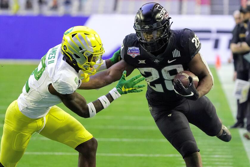 Iowa State running back Breece Hall tries to fend off Oregon cornerback DJ James during the Fiesta Bowl on Jan. 2, 2021.