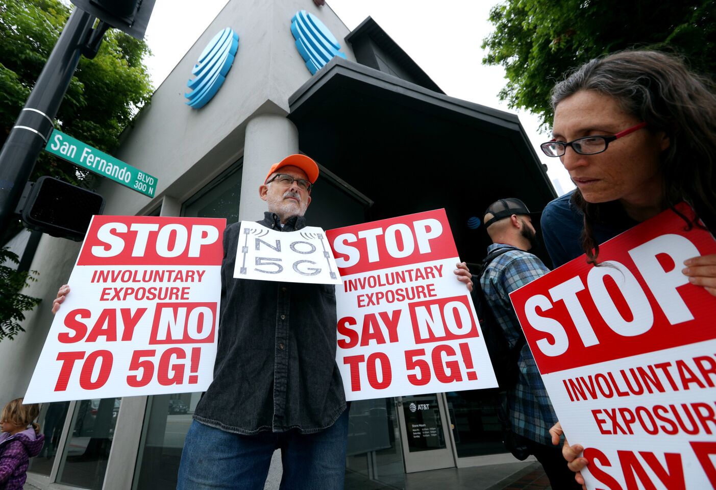 La Crescenta resident Ted Baumgart, left, and Karen Felzer, right, of Monrovia, hold signs against 5G outside the AT&T store on San Fernando Blvd., in Burbank on Wednesday, May 15, 2019.