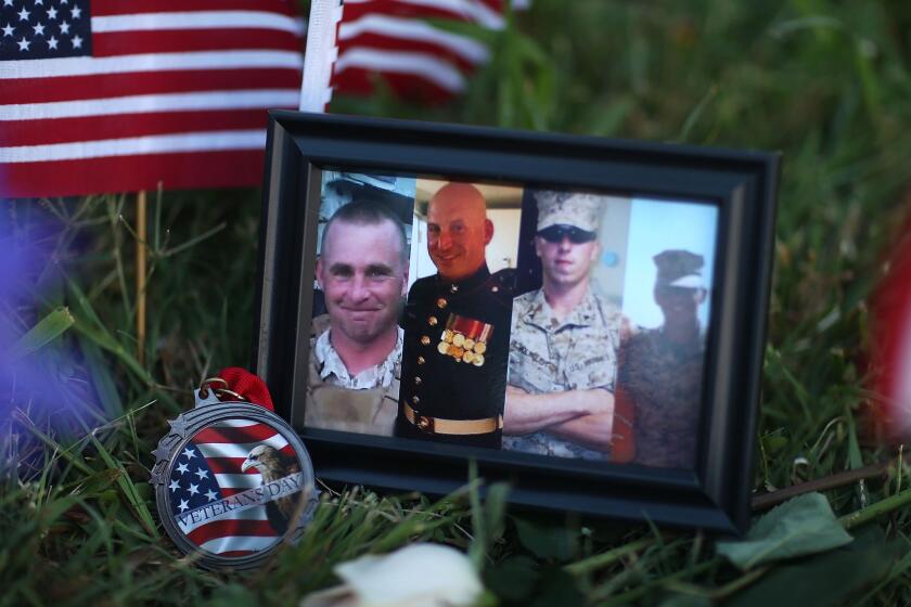 Photos of four slain Marines are placed at a makeshift memorial at a military recruiting center in Chattanooga, one of two military centers a gunman targeted. A fifth victim, a Navy sailor, has also died.