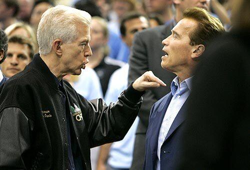 Former Governor Gray Davis is in a spirited talk with current Governor Arnold Schwarzenegger as the Southern California Trojans play the UCLA Bruins at Pauley Pavilion.