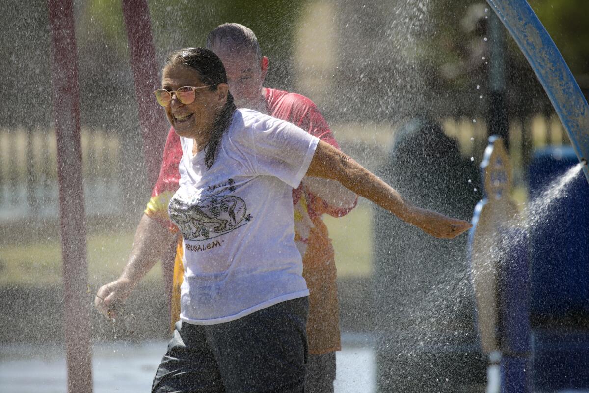 People smile under a spray of water.