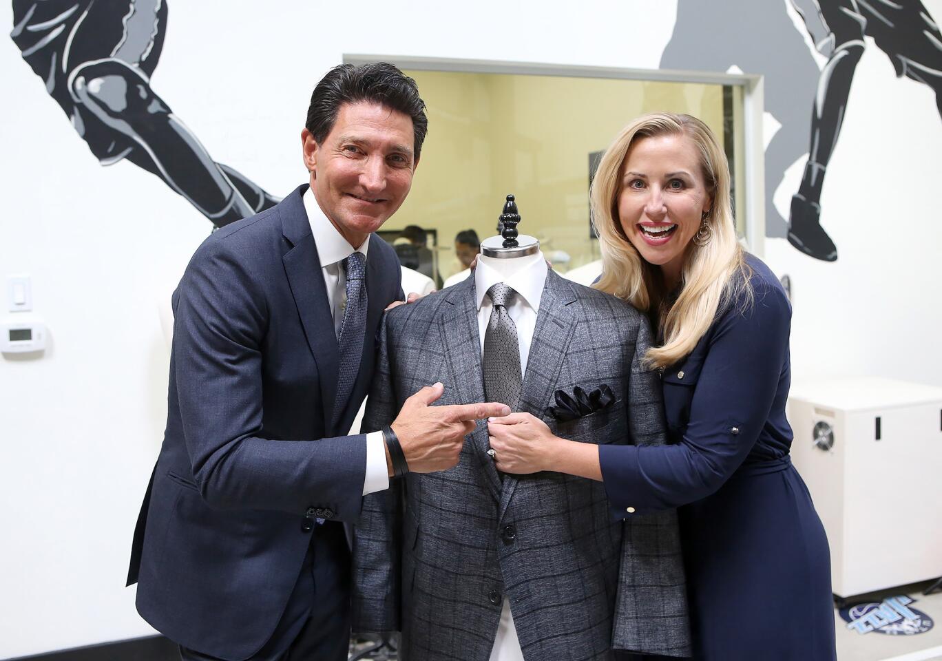 Clothier David Heil of David August, and Autumn Strier, co-founder and CEO of Miracles for Kids, dress a mannequin with one of the special ties that will benefit Strier's Tustin-based charity.