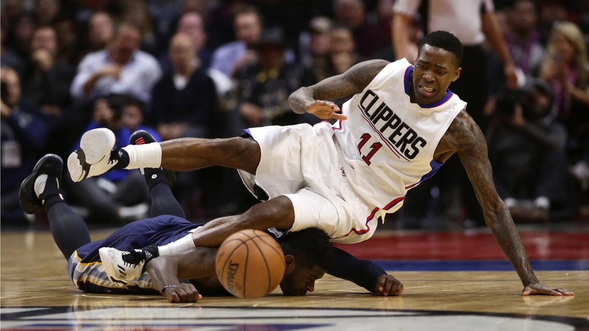 Clippers guard Jamal Crawford falls on Grizzlies forward James Ennis as they dive for a loose ball at Staples Center.