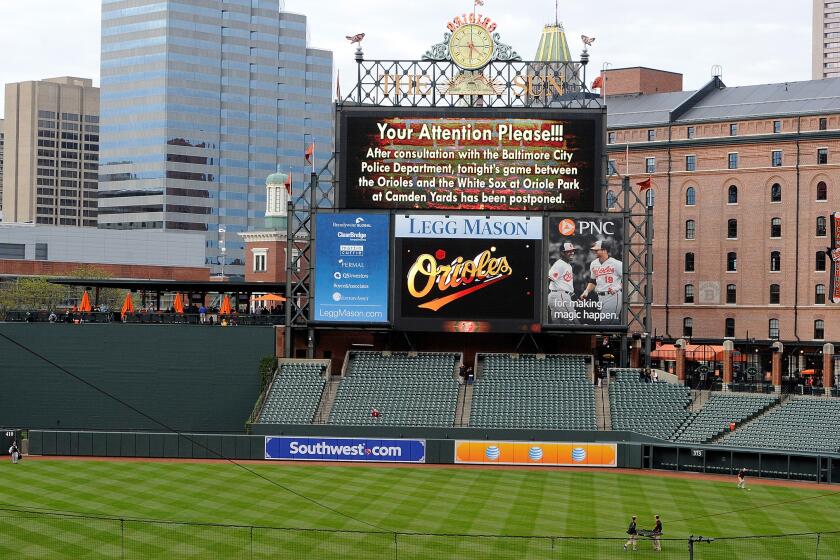 An announcement on the Camden Yards scoreboard notifies fans that game between the Orioles and White Sox has been postponed after civil unrest in the city.
