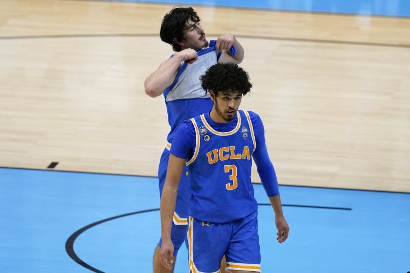 UCLA guards Johnny Juzang (3) and Jaime Jaquez Jr. walk off the court after losing in overtime to Gonzaga in the Final Four.