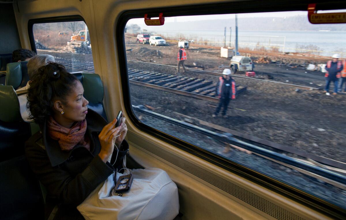 Passengers on a Metro-North train view ongoing repair work near the Spuyten Duyvil station in New York, where a fatal derailment disrupted service.