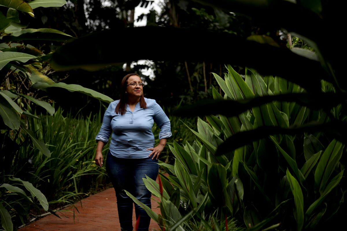 Lucía Pineda walks outdoors surrounded by greenery.