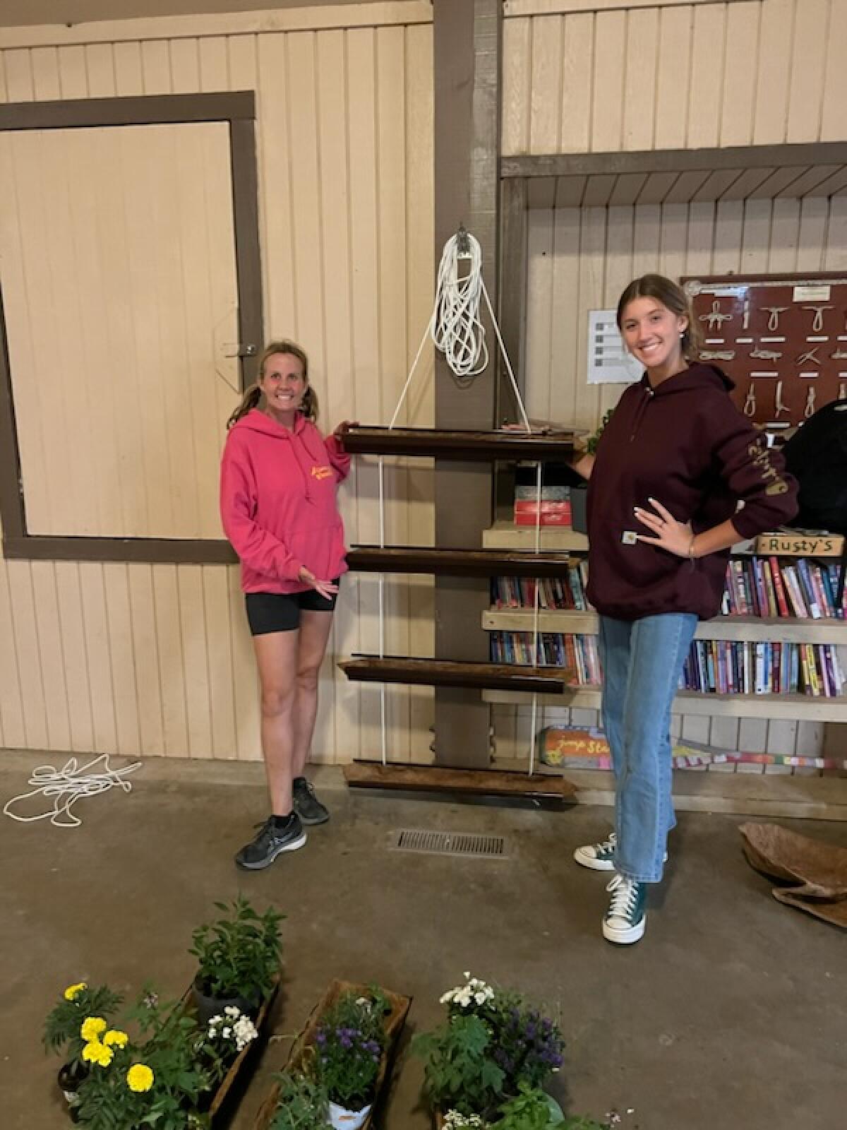 Kristine Rumbaugh (right) shows one of her custom-made vertical gardens with Girl Scout leader Jackie Fisk.