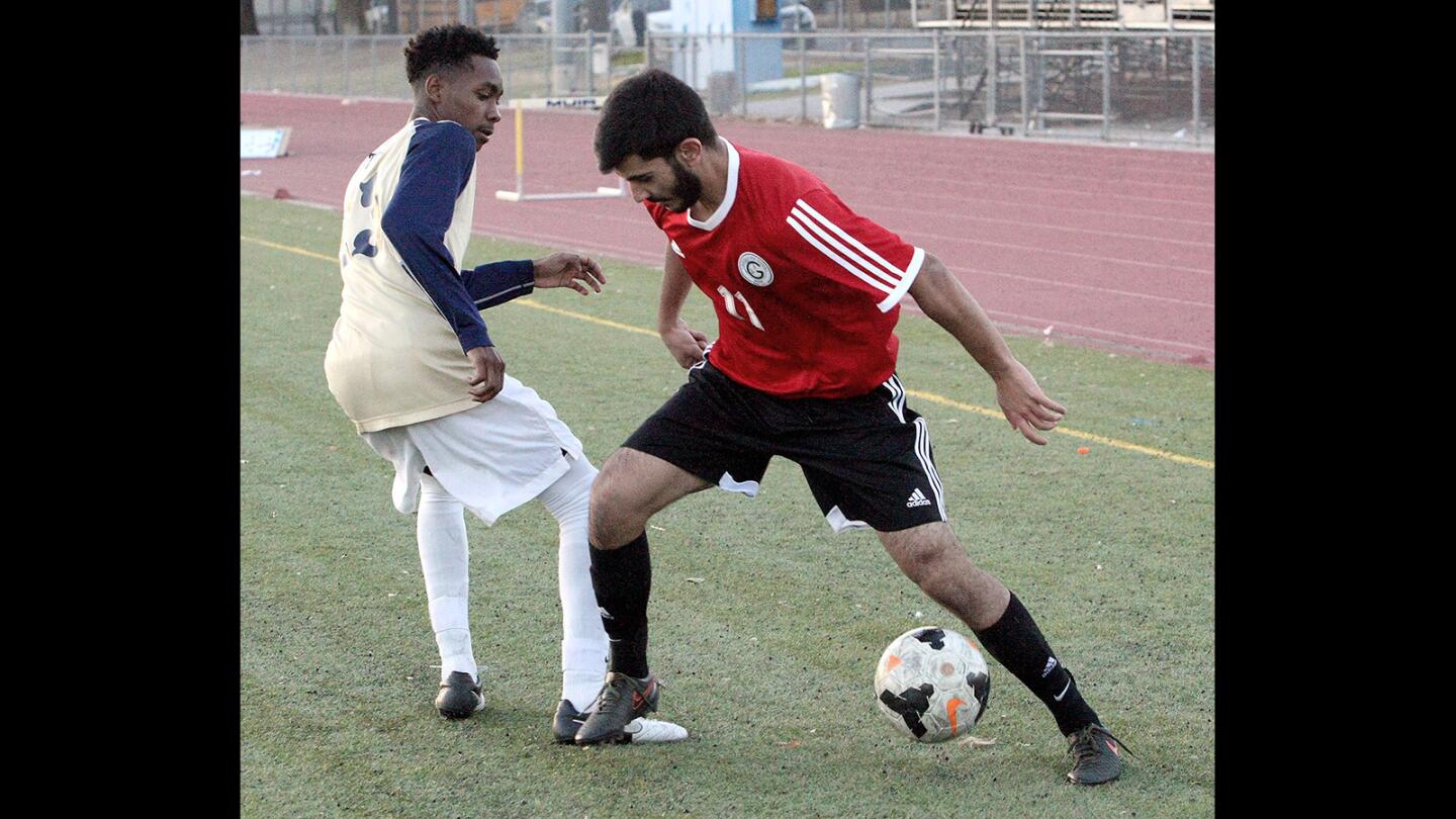 Glendale High's Arbi Khodavedian heads for the goal with Muir High's Elijah Grant defending during a game on Friday, Dec. 18, 2015.