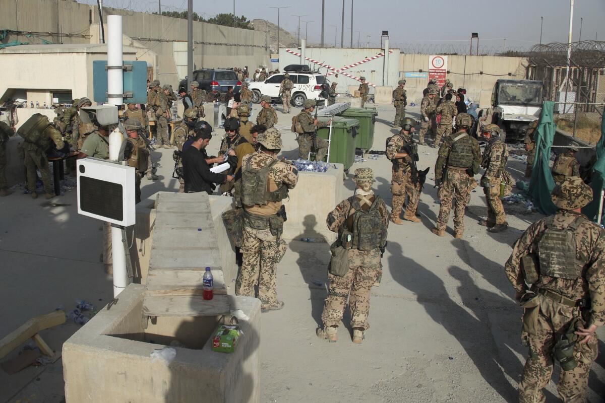 Members of the British and U.S. military help people evacuate