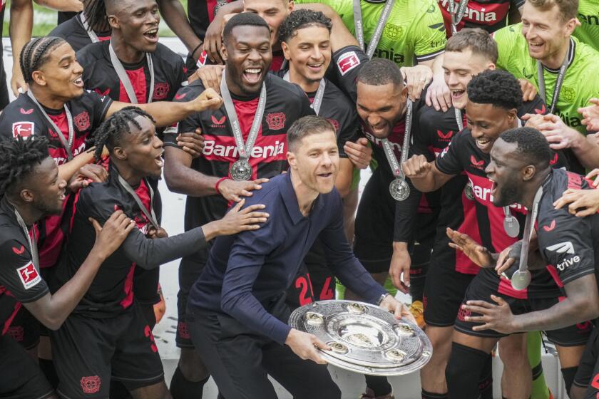 El técnico de Bayer Leverkusen Xabi Alonso celebra con el trofeo de campeones de la Bundesliga, el sábado 18 de mayo de 2024. (AP Foto/Michael Probst)