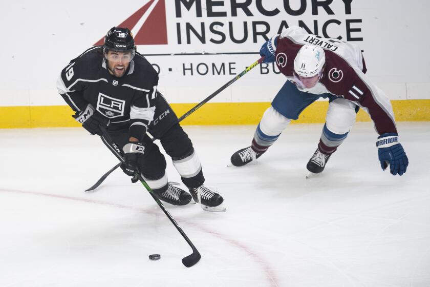 Los Angeles Kings right wing Alex Iafallo, left, controls the puck as Colorado Avalanche left wing Matt Calvert chases during the first period of an NHL hockey game Tuesday, Jan. 19, 2021, in Los Angeles. (AP Photo/Kyusung Gong)