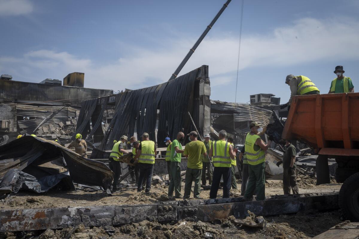 Workers clearing debris at damaged shopping center