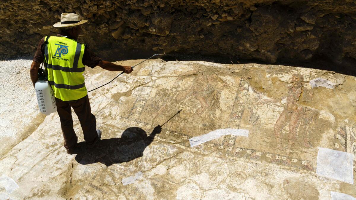 An archaeologist sprays water on a rare Roman mosaic that has been uncovered in the Mediterranean town of Larnaca, Cyprus.