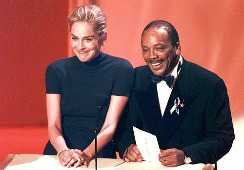 Sharon Stone, with Quincy Jones at the 1996 Oscars, raised eyebrows by sporting a turtleneck shirt from the Gap at the glitzy event.