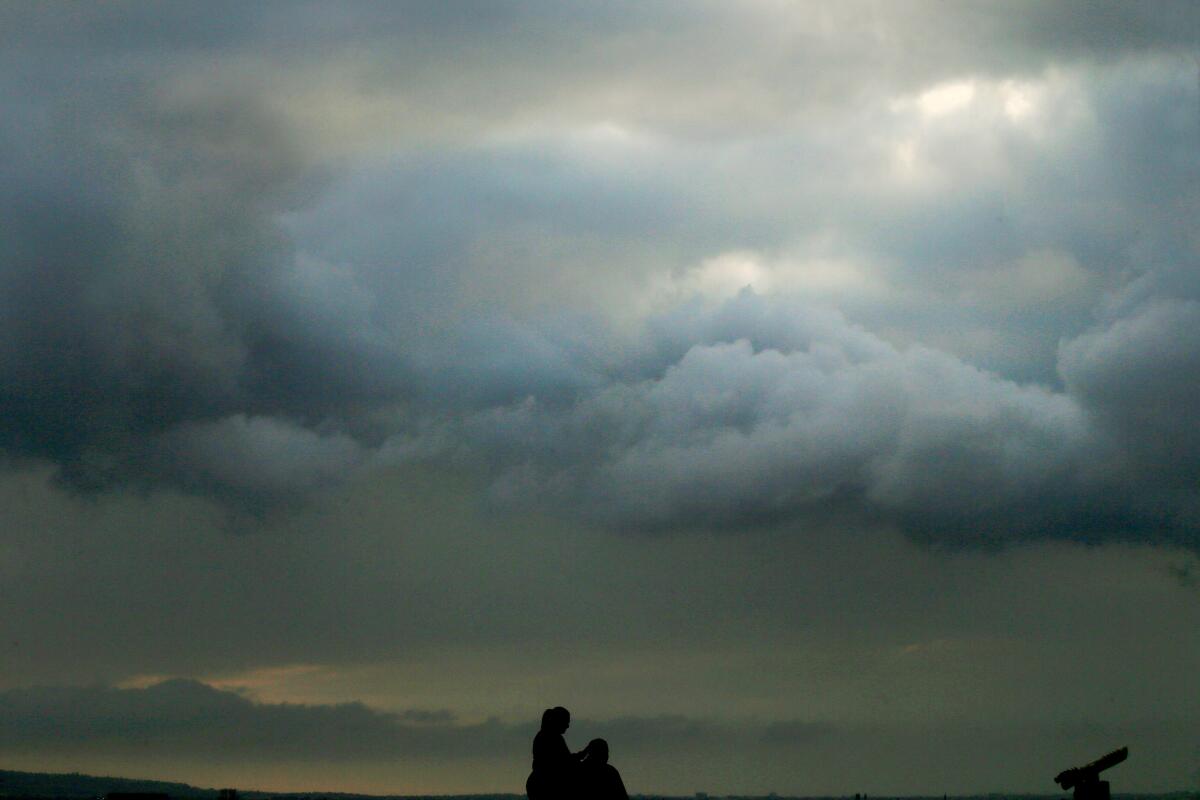  Two people with gray clouds above them.