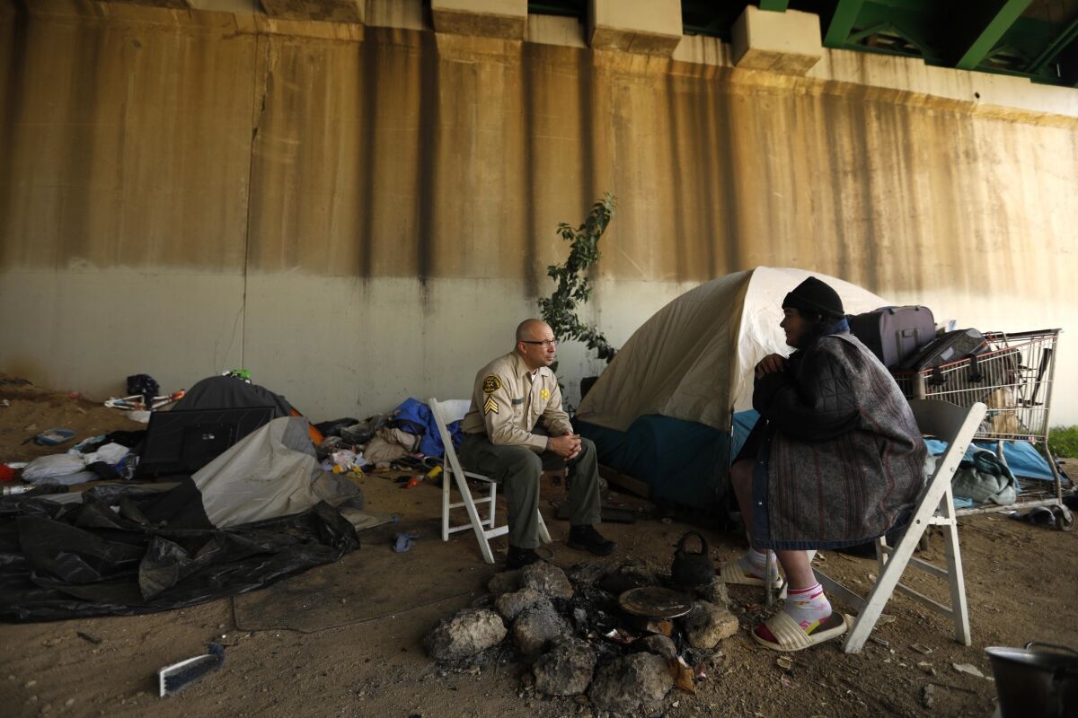 Sheriff Deputy Sgt. William Kitchin talks with Leah Davalos under an overpass while she was recorded for the 2019 Greater Los Angeles Homeless Count in the City of Commerce.