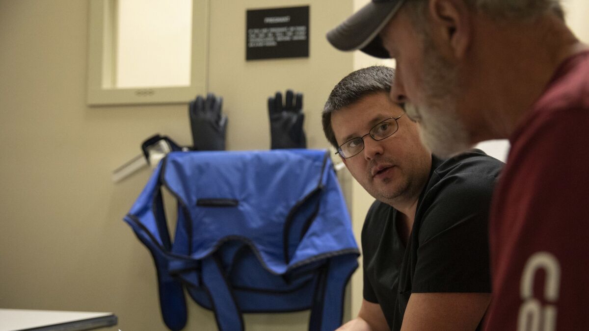 Dr. Brandon Crum talks with Jimmy Cline, 66, of Gilbert, W.Va., about this X-ray results on Dec. 20. Crum describes black lung as an "epidemic" in the region.