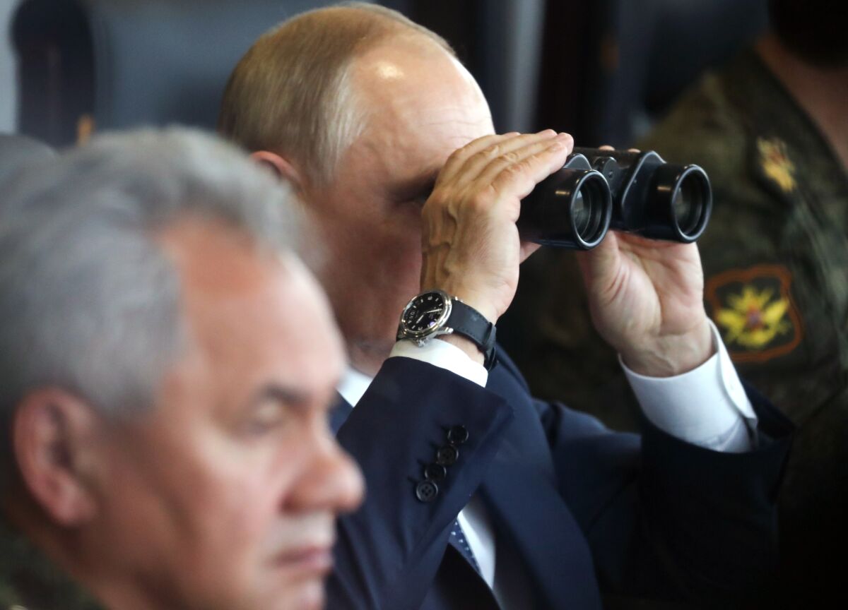 FILE - Russian President Vladimir Putin, center, watches through binoculars as Russian Defense Minister Sergei Shoigu sits near during the joint strategic exercise of the armed forces of the Russian Federation and the Republic of Belarus Zapad-2021 at the Mulino training ground in the Nizhny Novgorod region, Russia, on Sept. 13, 2021. Putin's threats to use "all the means at our disposal" to defend his country as it wages war in Ukraine have cranked up global fears that he might use his nuclear arsenal, with the world's largest stockpile of warheads. (Sergei Savostyanov, Sputnik, Kremlin Pool Photo via AP, File)