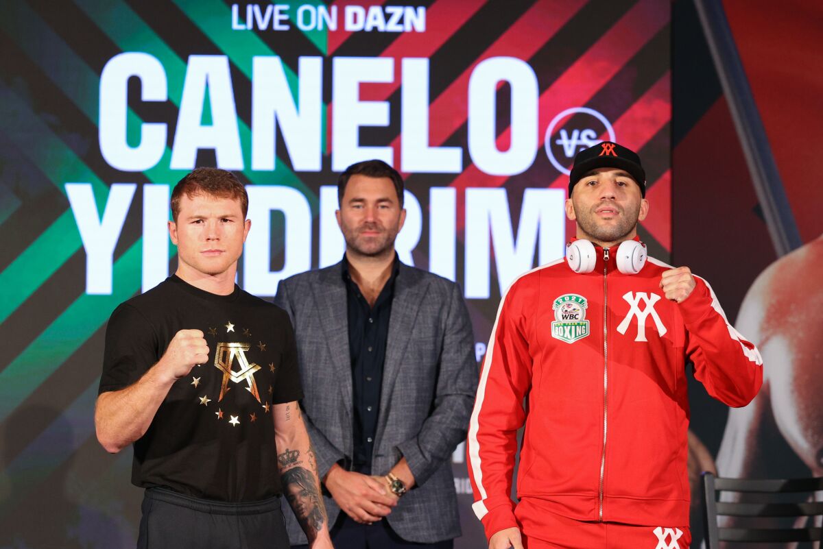 Canelo Alvarez, left, and Avni Yildirim strike poses at a news conference in Miami earlier this week.