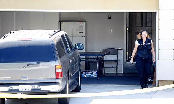 A police investigator walks from the Porter Ranch house where officials say an unemployed financial advisor apparently despondent over his troubles shot and killed his wife, his mother-in-law and three children before taking his own life.