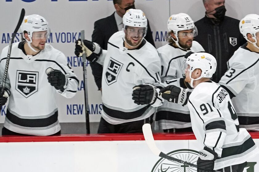 Los Angeles Kings' Carl Grundstrom (91) is congratulated by teammates after his go-ahead goal off Minnesota Wild goalie Kaapo Kahkonen (34) in the third period of an NHL hockey game, Tuesday, Jan. 26, 2021, in St. Paul, Minn. The Kings won 2-1. (AP Photo/Jim Mone)