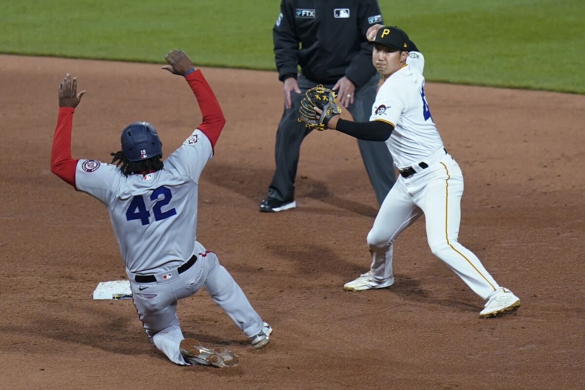 Pittsburgh Pirates shortstop Hoy Park, right, throws on to first for the out on Washington Nationals' Keibert Ruiz, after forcing out Josh Bell, left, on a double play during the sixth inning of a baseball game, Friday, April 15, 2022, in Pittsburgh. (AP Photo/Keith Srakocic)