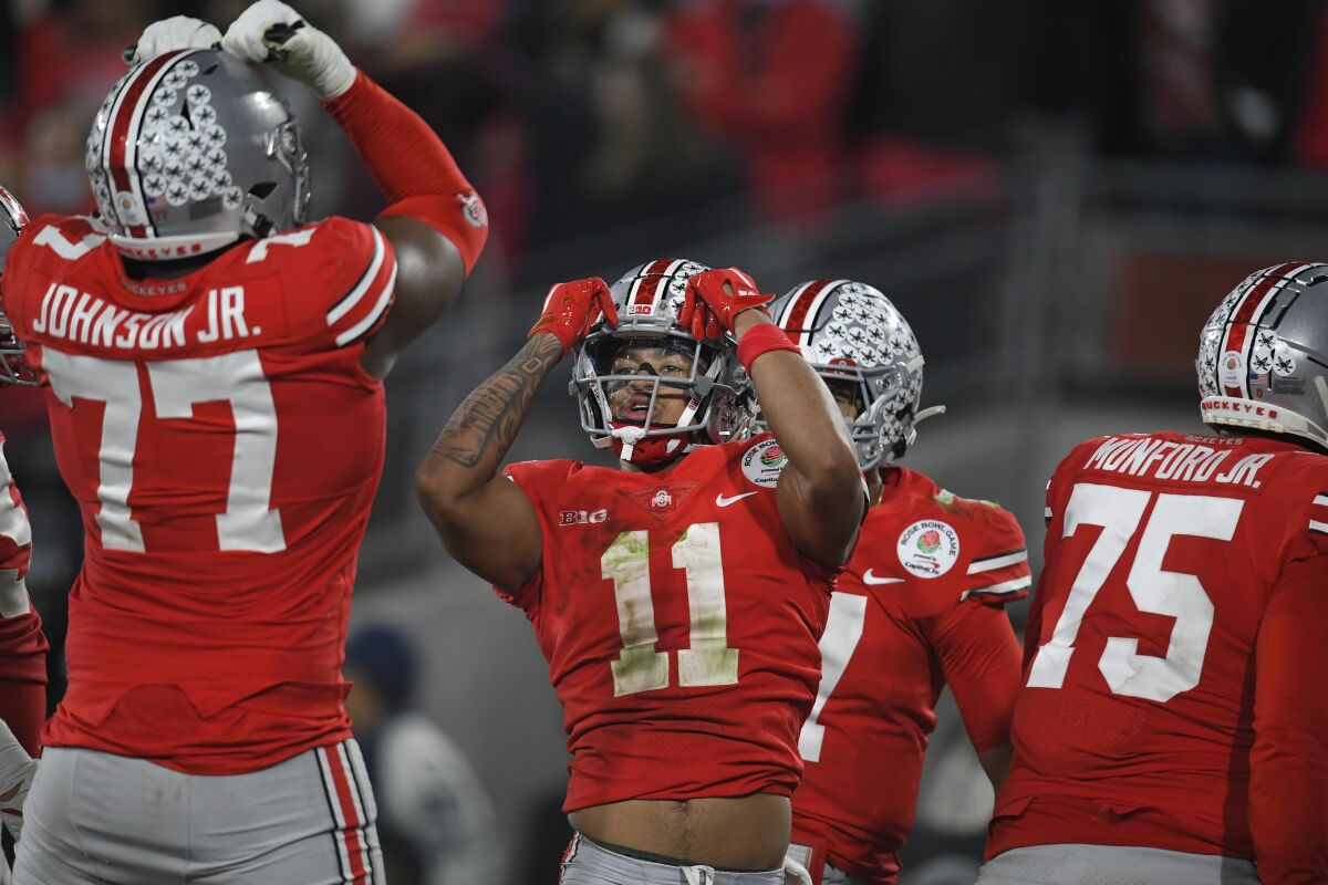 Ohio State wide receiver Jaxon Smith-Njigba (11) celebrates his touchdown catch with offensive lineman Paris Johnson Jr. (77) during the second half in the Rose Bowl NCAA college football game against Utah Saturday, Jan. 1, 2022, in Pasadena, Calif. (AP Photo/John McCoy)