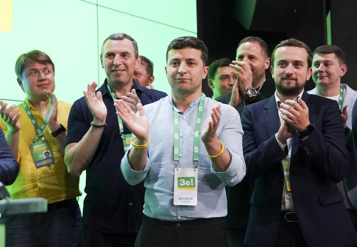 Ukrainian President Volodymyr Zelensky, center, monitors election results at his party's headquarters in the capital, Kiev.