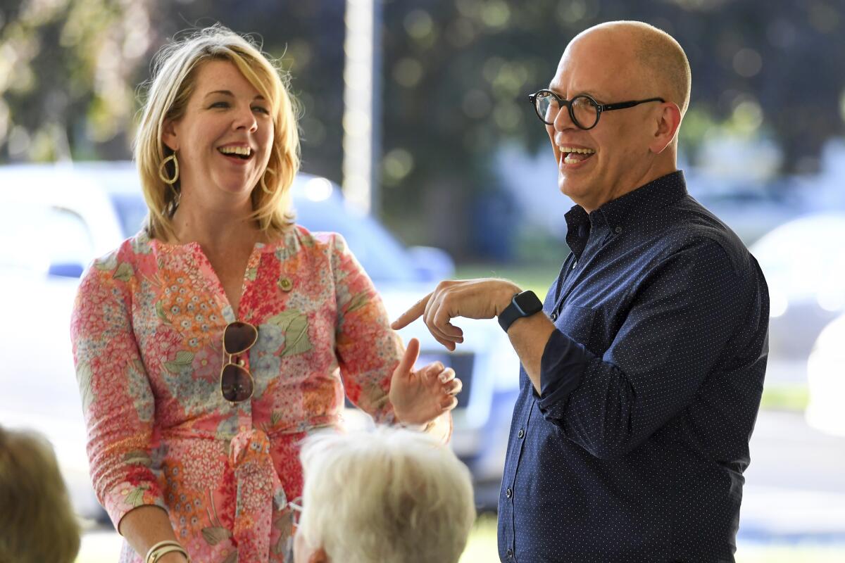 Ohio House Democratic Leader Allison Russo, left, and Ohio House House District 89 Candidate Jim Obergefell, right, laugh during a meeting of the Democratic Women of Erie County at Strickfaden Park, Monday, July 18, 2022, in Sandusky, Ohio. Obergefell is hoping that Democrats can win back seats at the Ohio Statehouse and beyond this fall with a message grounded in his landmark U.S. Supreme Court fight for same-sex marriage. (AP Photo/Nick Cammett)