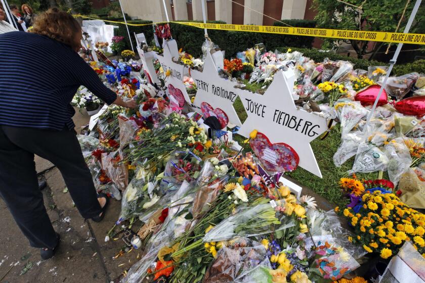 Flowers are placed Thursday, Nov. 1, 2018, at a makeshift memorial outside the Tree of Life Synagogue to the 11 people killed Oct 27, 2018 while worshipping in the Squirrel Hill neighborhood of Pittsburgh. (AP Photo/Gene J. Puskar)