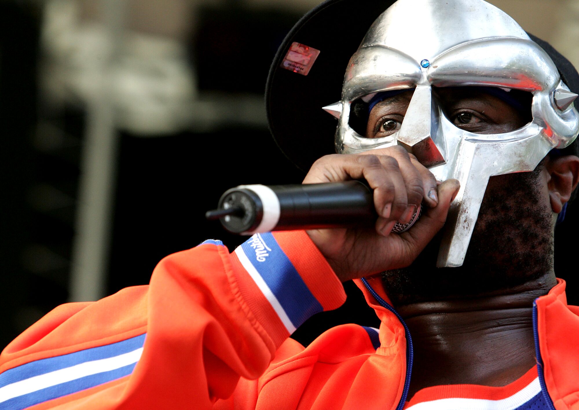 A rapper in a mask performs onstage.