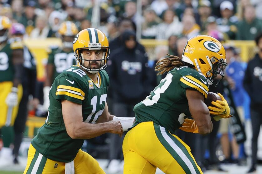 Green Bay Packers quarterback Aaron Rodgers (12) passes the ball to running back Aaron Jones (33) during the second half of an NFL football game against the New England Patriots, Sunday, Oct. 2, 2022, in Green Bay, Wis. (AP Photo/Kamil Krzaczynski)
