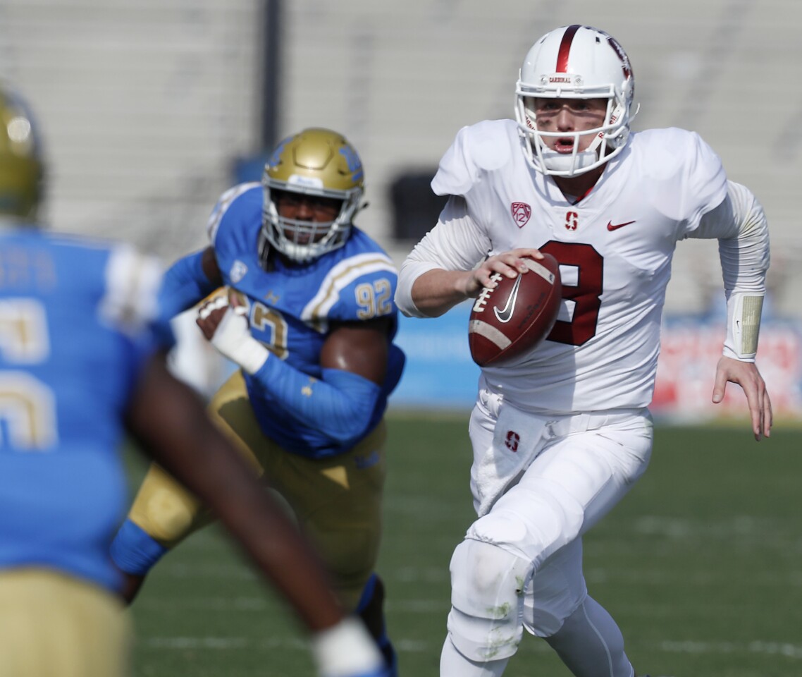 Stanford quarterback KJ Costello scrambles for a gain against the Bruins during the first quarter.