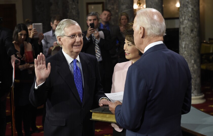 FILE - In this Jan. 6, 2015, file photo, then-Vice President Joe Biden, right, administers the Senate oath to Senate Majority Leader Mitch McConnell of Ky. during a ceremonial re-enactment swearing-in ceremony in the Old Senate Chamber on Capitol Hill in Washington. McConnell's wife, Elaine Chao is at center. President Joe Biden’s sit-down on May 12, 2021, with Senate Republican leader Mitch McConnell and other congressional leaders comes as the White House accelerates its efforts to reach a bipartisan infrastructure agreement, or at least aims to show it’s trying. (AP Photo/Susan Walsh, File)