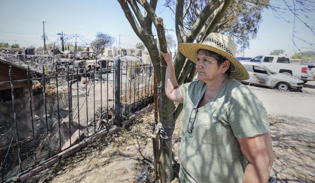 Ana Valenzuela stares at the pile of ashes and debris where her home in Niland, Calif., once stood. 