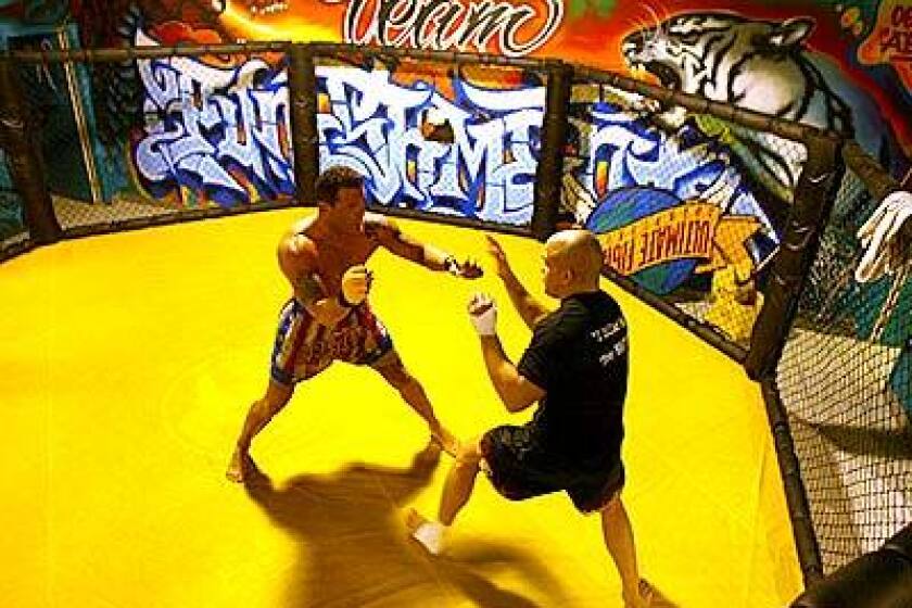 Tito Ortiz, right, goes through a sparring session at the Ultimate Training Center in Huntington Beach. Closed-fist punches to the head are prohibited at the matches in Huntington Beach.