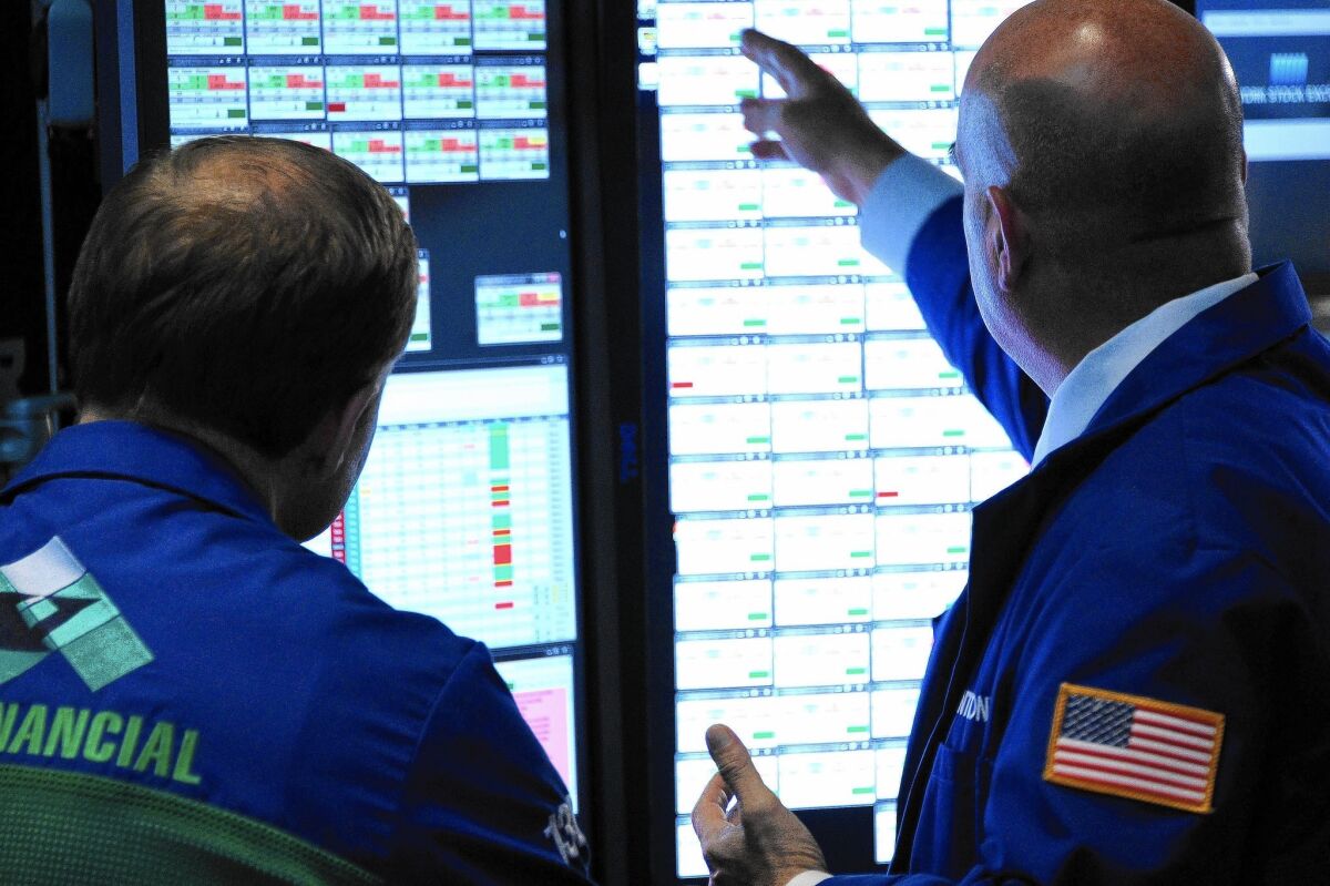 Traders work on the floor of the New York Stock Exchange on Thursday, another volatile trading day.