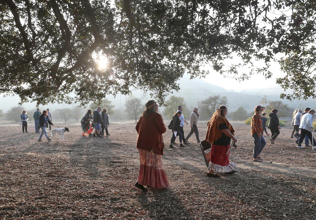 Guests walk under the canopy of the Mother Tree at the new Putuidem Village in San Juan Capistrano.