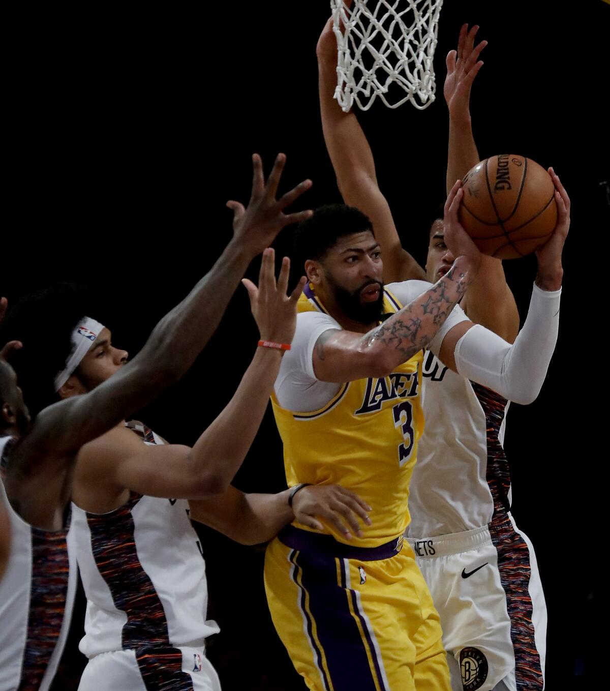 Lakers forward Anthony Davis draws a crowd of Nets during the fourth quarter of a game March 10 at Staples Center. 